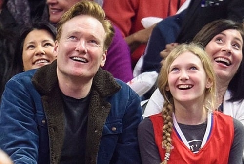 A picture of Neve O'brien attended the Los Angeles Clippers' match at the Stapples areba with her father, Conan O'Brien .